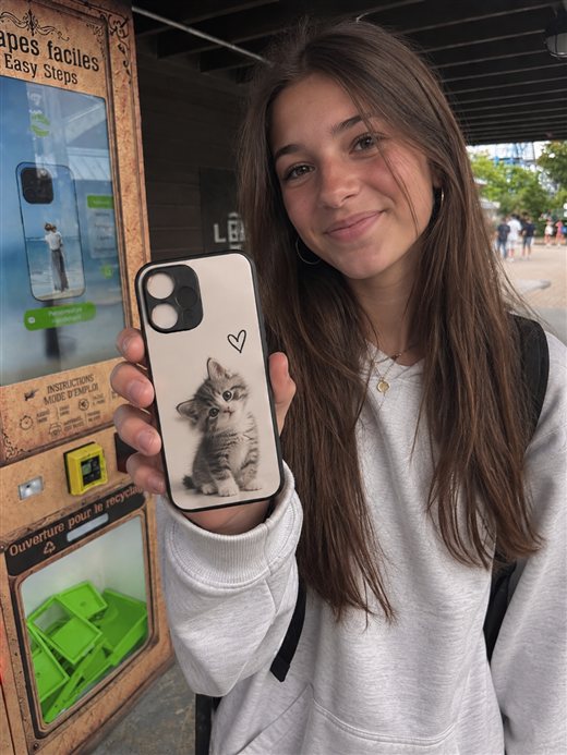 Cliente tenant sa coque personnalisée CaseXpress avec un chaton et un cœur