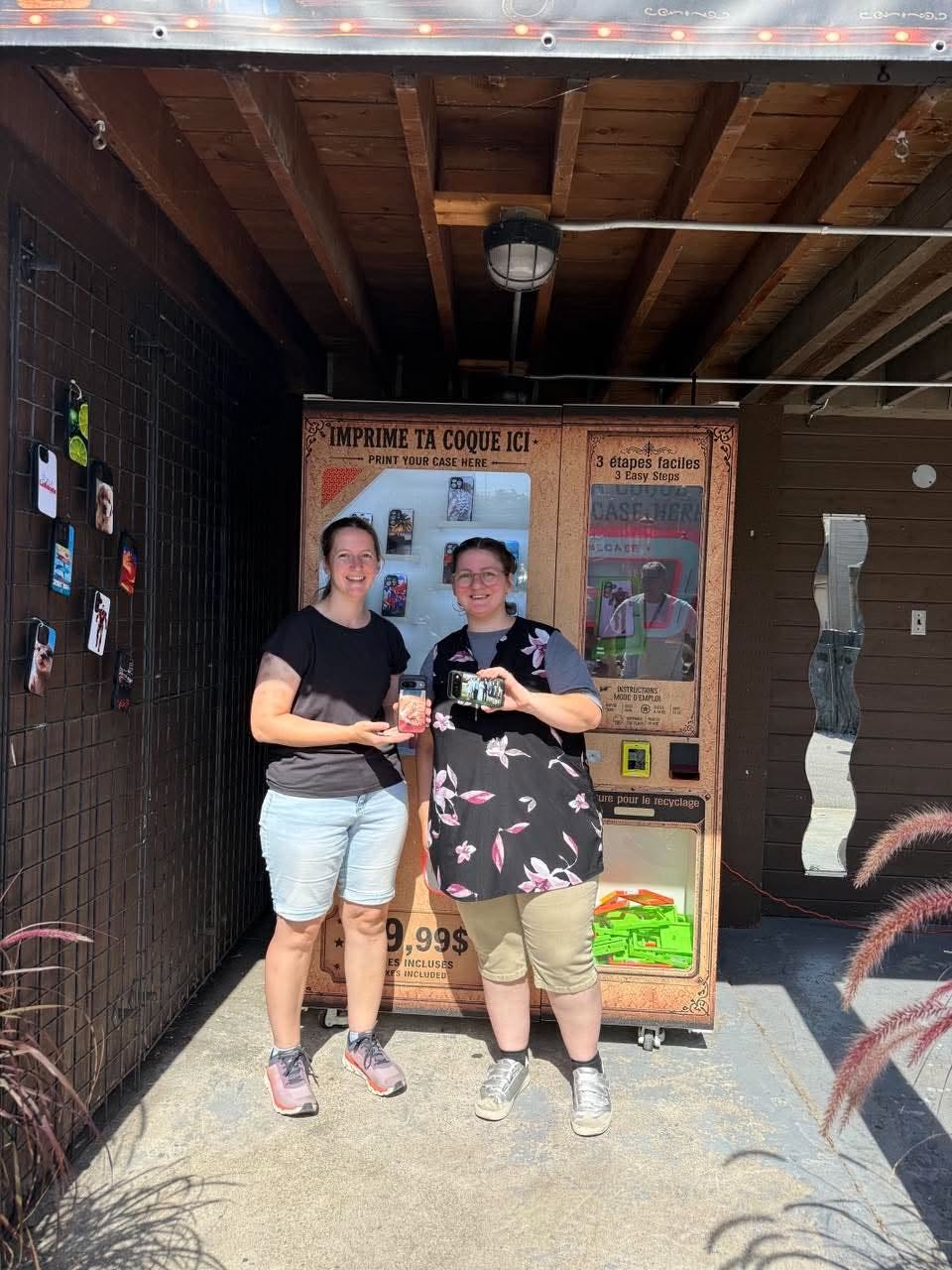 Deux amies tenant leurs coques devant la borne CaseXpress