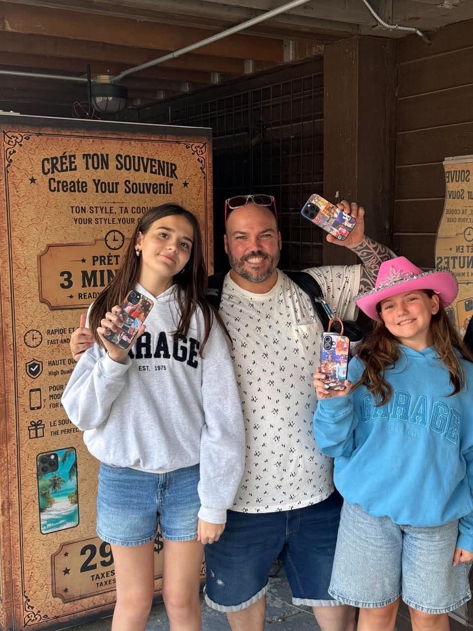 Un père et ses deux filles tenant leurs coques personnalisées